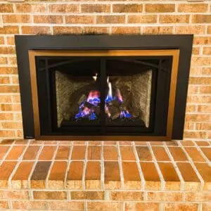 burning direct vent gas fireplace with masinry surrond