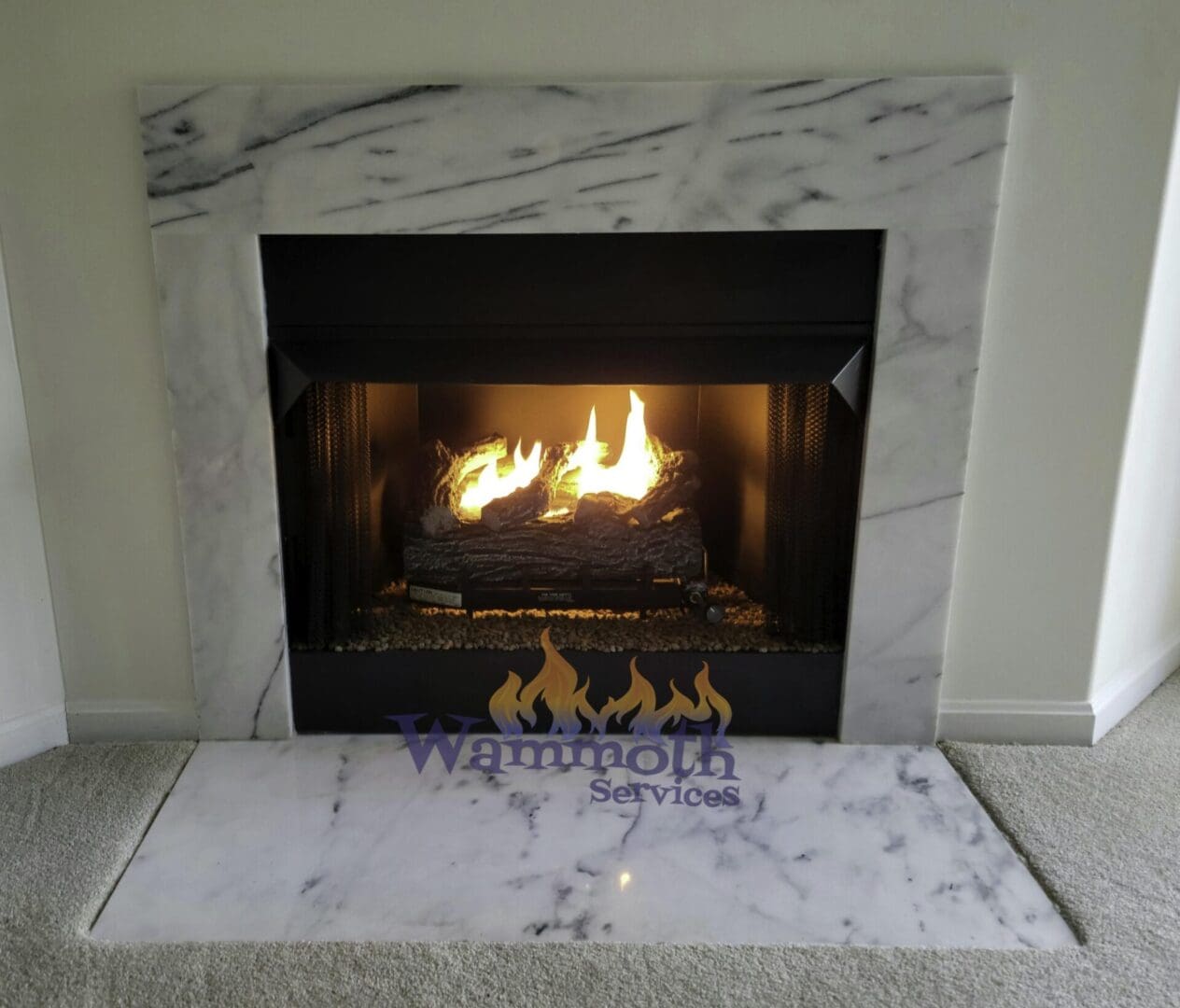 burning gas fireplace with marble surround and hearth