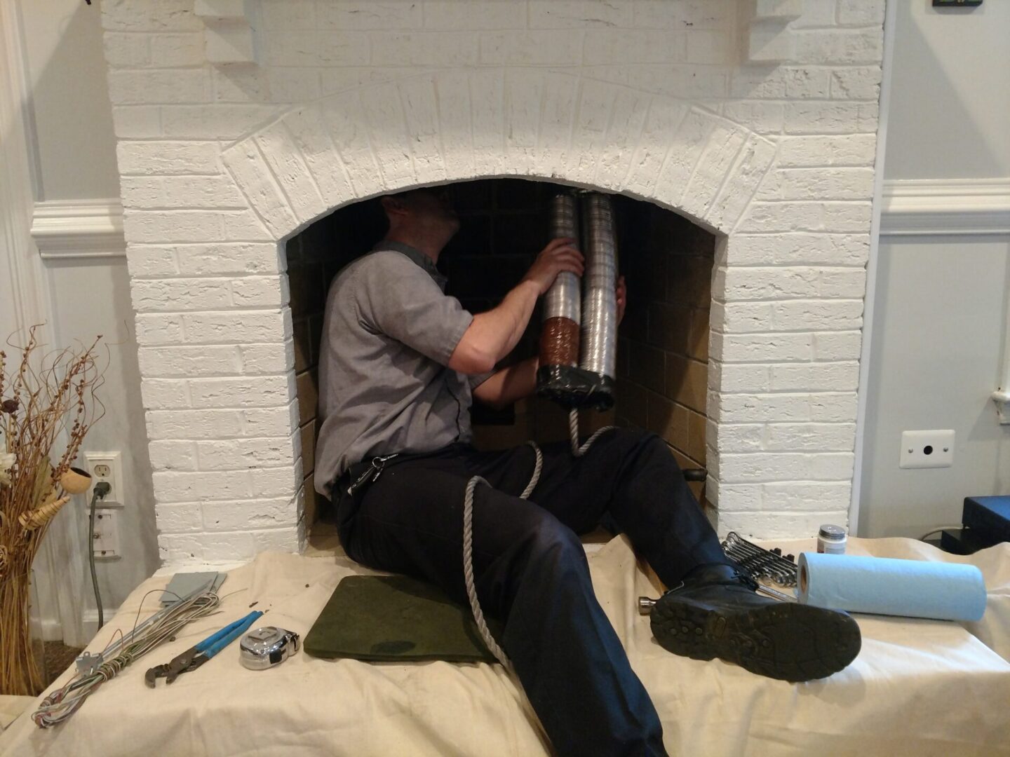 technician in a firebox installing a chimney liner